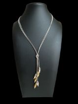 A silver bi-coloured drop necklace. The necklace with a silver chain stamped 925, from which three
