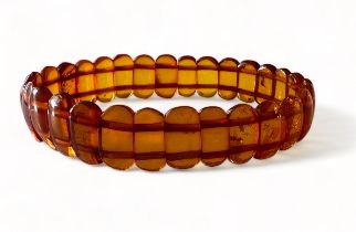 An amber bracelet comprised of shaped amber cabachons attached to two strings of elastic. Please see