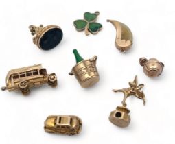 A range of eight gold charms, six fully hallmarked, two (talon and bottle) stamped 9ct. Total weight