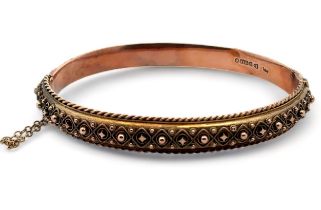 An Edwardian bangle with fancy metal work and rope twist edging. 9ct rose gold with hallmarks for