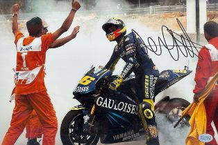 Framed signed Valentino Rossi race win picture. Rossi performing a burnout after a race win. COA