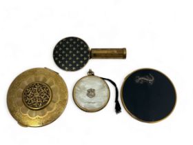 Three powder compacts. Includes a Kigu compact, a Vogue compact with marcasite lizard decoration,