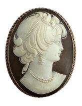 A shell cameo brooch depicting a lady in profile with 9ct rope twist surround. Marks on reverse