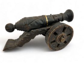 A large carved wooden cannon, approx 50cm in length.