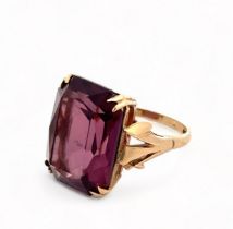 A modern dress ring set with an octagonal purple paste gemstone, imitating amethyst. Paste stone