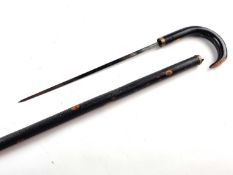 A Victorian gentleman's sword cane, with a lacquered black wooden shaft and a handle pulling out