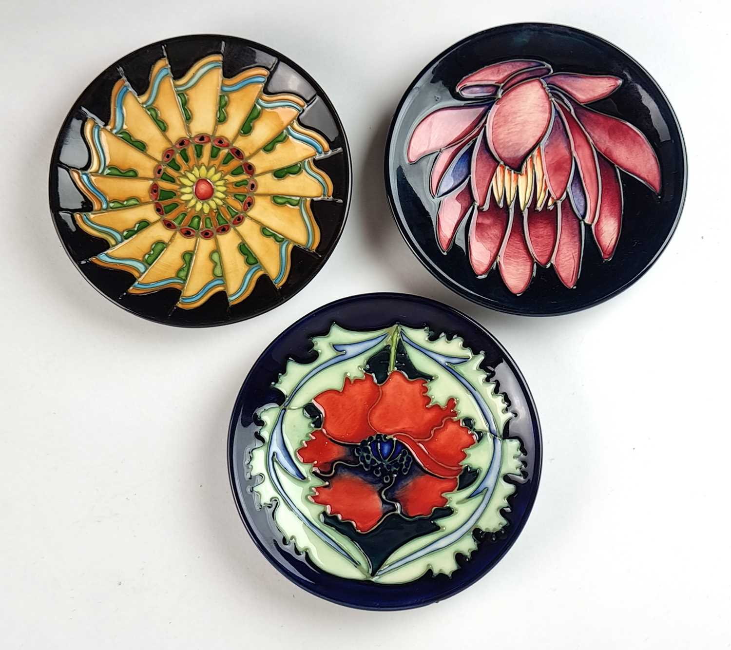 Three Moorcroft pin dishes including May Lily and Moorcroft Poppy