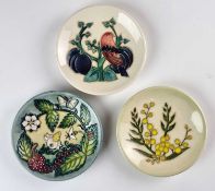 Three Moorcroft pin dishes including 'Fruit Garden'