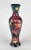 A tall Moorcroft vase in the 'Portelet Bay' (red orchid) pattern, created for the Connoisseur