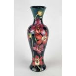 A tall Moorcroft vase in the 'Portelet Bay' (red orchid) pattern, created for the Connoisseur