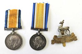 Two single First World War Medals and a re-strike cap badge.