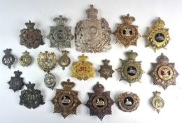 A collection of twenty helmet plates and cap badges etc, North Staffordshire, South Staffordshire,