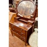 An Edwardian mahogany dressing table, oval mirror held by fluted supports with carved corners, above