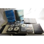 A large collection of cds cased in 6 albums covering different types of music, an atlas and a