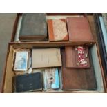 A leather travelling case with brass latches, together with various books, postcards and a stained