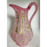 A late 19th century pink tinted glass jug with opaque panels enamelled with stylised foliate