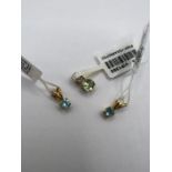 Three small yellow metal pendants - two set with topaz and the third with green spodumene and