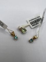 Three small yellow metal pendants - two set with topaz and the third with green spodumene and
