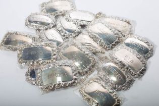 A collection of 19 Elizabeth II sterling silver spirit labels on chains, including labels for