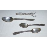 A pair of white metal cast and foliate pierced tongs, a pair of German silver teaspoons with