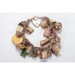 A 9ct rose gold bracelet with a padlock clasp, used as a charm bracelet and featuring 22 charms,