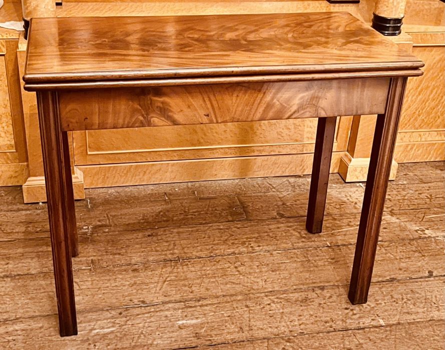 A George III mahogany card table, circa 1820, rectangular form, fold-over top enclosing a material