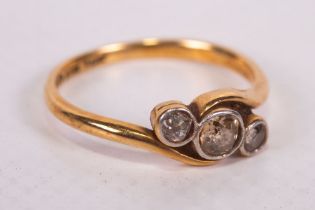 An early 20th century diamond set crossover ring in yellow metal stamped 18ct and Plat. The