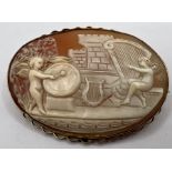 A 9ct stamped oval shell cameo brooch, carved to depict putti with drum and harp. Approximate gross