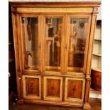 An early 20th century oak glazed display cabinet, lighter oak inlay, three glazed doors, flanked