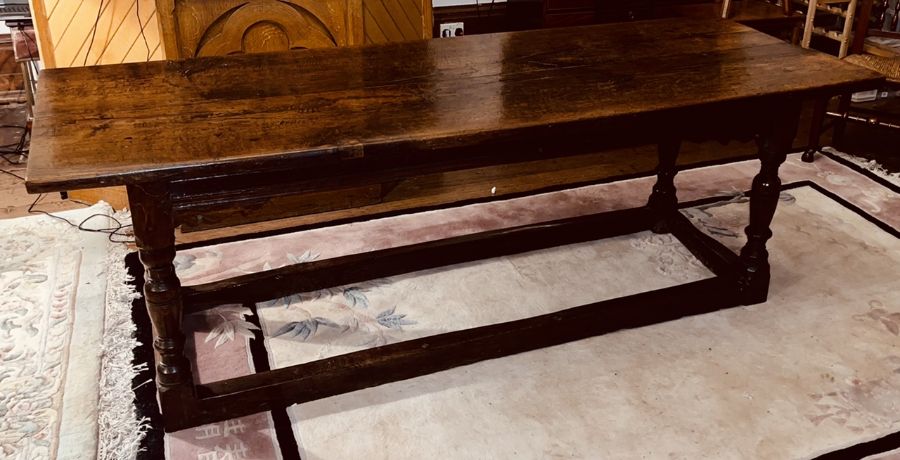 A Charles I oak refectory table, circa 1630, two plank top, raised on baluster on block supports