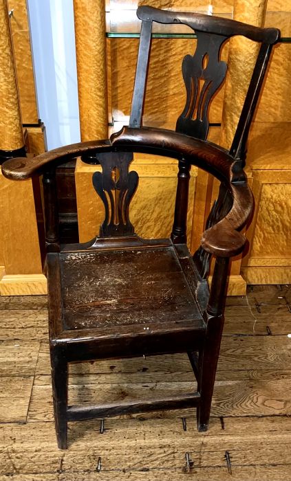 A George II elm corner chair, circa 1740, comb back top on urn shaped pierced splat, curve