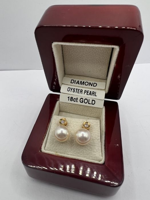 A pair of 18ct gold cultured pearl and diamond ear studs. The pearls measure approximately 8mm.