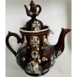 A large Victorian bargeware teapot and cover in treacle glaze and with sprigged decoration, the
