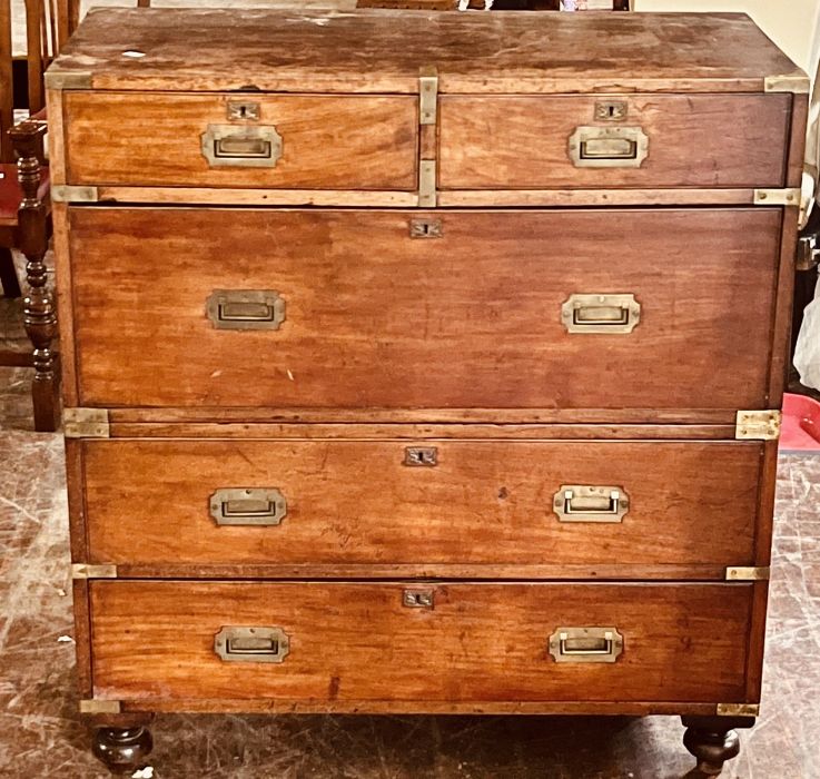 A Victorian mahogany and brass bound campaign chest, two short and three long drawers, raised on