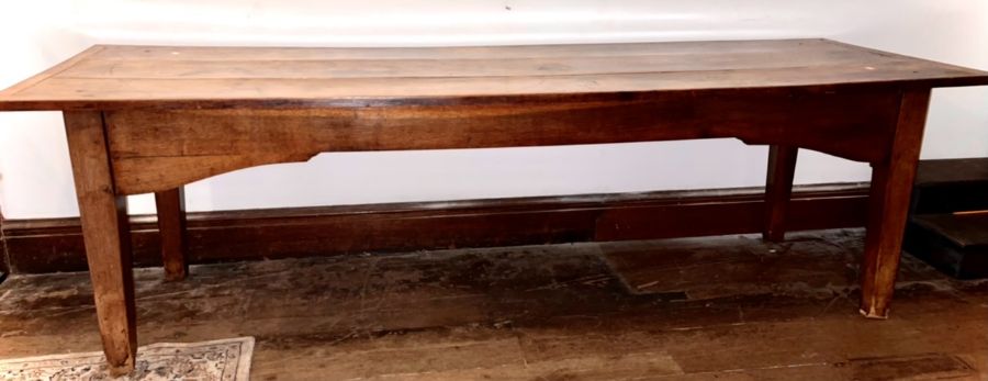 A George III oak and elm farmhouse table, three plank with cleated ends top, raised on tapered