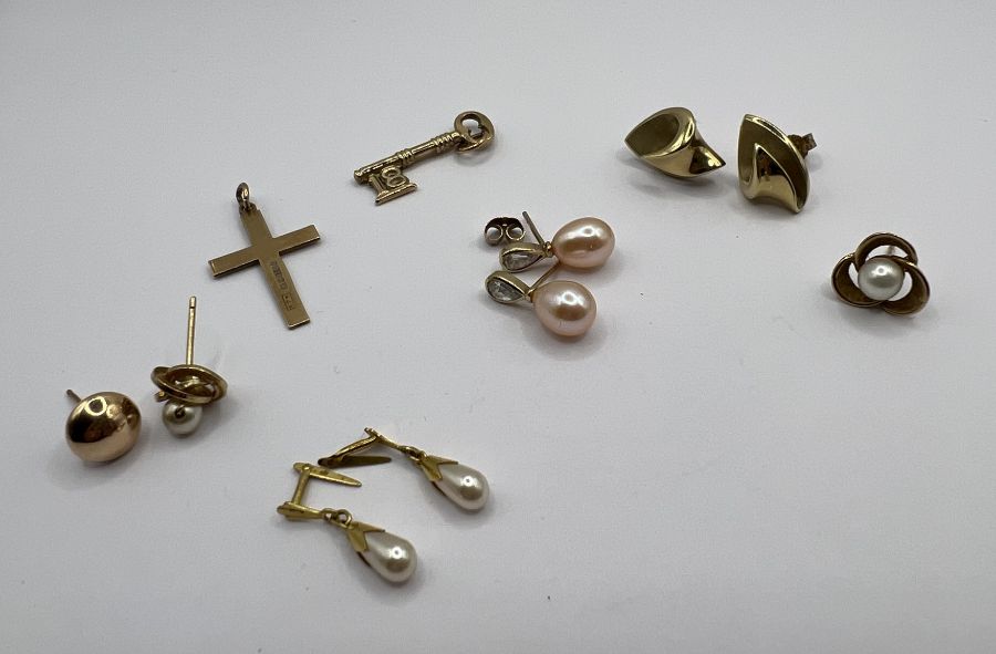 A pair of 9ct gold organic fold ear studs, along with a 9ct gold cross, a 9ct gold "18" key plus two