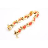 A yellow metal bracelet bezel set with cabochons of coral, with a granulated design, with functional