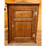 A George III oak corner cupboard, circa 1820, moulded cornice, above moulded panel door enclosing