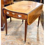 A George III mahogany and satinwood crossbanded pembroke table in a Thomas Sheraton manner.