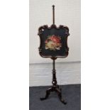 A Victorian rosewood pole screen with swept framed floral needlework panel, on downswept legs and