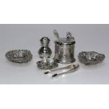 A selection of sterling silver tableware comprising a pepper pot, a set of sugar tongs, a lined,