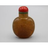 Snuff Bottle. Chalcedony of flattened rounded shape resting on a small oval base, the darker