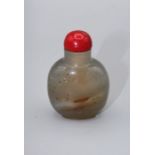 Snuff Bottle. Chalcedony of rounded form with a footrim, lightly carved, using the darker tone areas