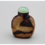 Snuff Bottle. Chalcedony of compressed ovoid form on a raised footrim, the dark swirling markings