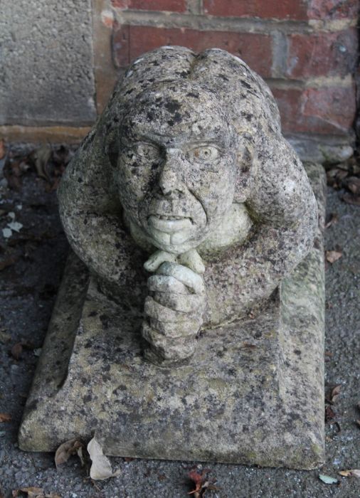 A reconstituted stone model of a kneeling goblin type creature, on rectangular plinth, 39 x 55 x