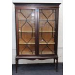 An Edwardian mahogany vitrine, the moulded and dentil cornice over blind fret carved frieze and a