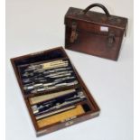 An early 20th century burr walnut and white metal mounted cased set of drawing instruments, the