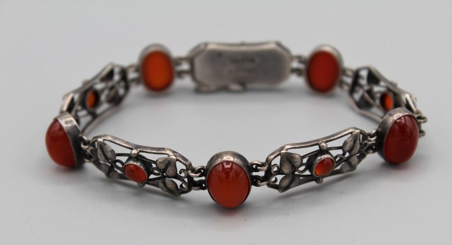 A Liberty and Co Arts and Crafts bracelet, formed by five panels, with a central round carnelian