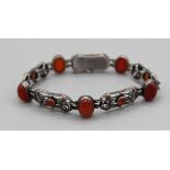 A Liberty and Co Arts and Crafts bracelet, formed by five panels, with a central round carnelian