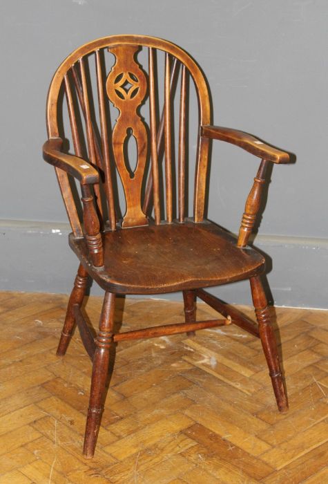 A 19th century beech and elm wheel and stick back Windsor armchair, with saddle seat on ring